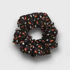 Duo de scrunchies de cetim mate e seda chifon, um liso e um com padrão triangulos, ambos em tons de azul.